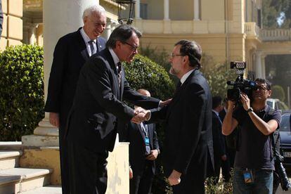 Artur Mas i Mariano Rajoy, amb Margallo al fons, se saluden a la cimera.