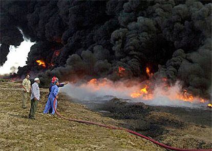 Bomberos iraquíes trabajan en la extinción de un fuego provocado por un sabotaje contra un oleoducto cercano a la ciudad de Basora.