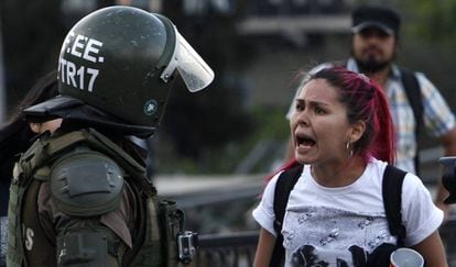 Una manifestante discute con un carabinero en las protestas de Santiago de Chile.