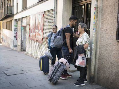 Tres personas llegando a un piso de alquiler turístico.