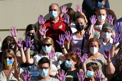 Un grupo de personas con las manos moradas guardan un minuto de silencio en Málaga tras el asesinato machista de una mujer el pasado julio.