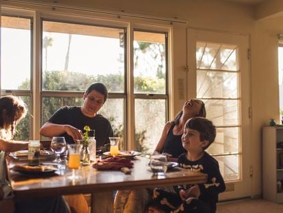 Una familia se sienta junta para comer.