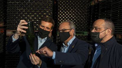 Pablo Casado, junto a Josep Tutusaus, alcalde de Pontons,  y el presidente del PP catalán Alejandro Fernández durante su visita a una bodega de cava. (Efe)