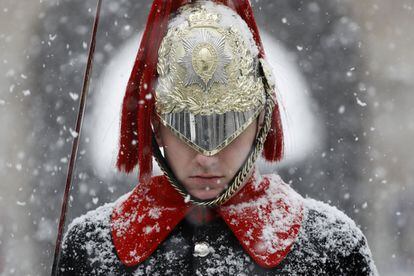 Retrato de un miembro del Regimiento Montada de la Caballería Doméstica bajo la nieve, en Whitehall, en el centro de Londres (Reino Unido).