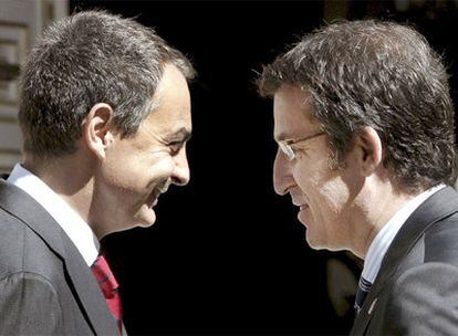 Zapatero y Feijóo bromean, ayer, a las puertas del Palacio de la Moncloa.