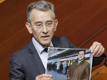 El socialista Antonio Torres muestra una foto de Rajoy durante el pleno de este jueves en las Cortes.