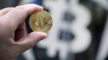 Una moneda de bitcoin sobre el símbolo de la criptodivisa.