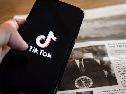 Un móvil con el logo de TikTok sobre una imagen de Donald Trump en un periódico.