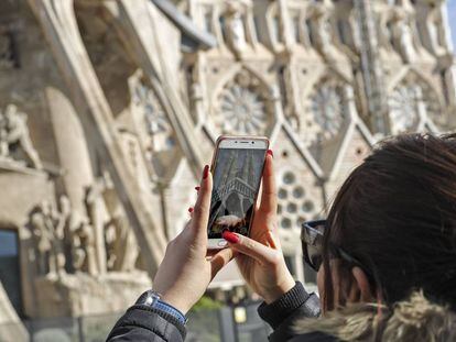 Una mujer fotografía la Sagrada Familia.