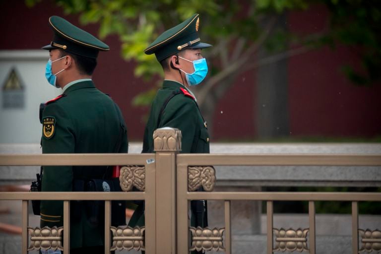 Policías con mascarilla patrullan en la plaza de Tiananmen, donde se encuentra el Gran Palacio del Pueblo, sede de la Asamblea Nacional Popular.