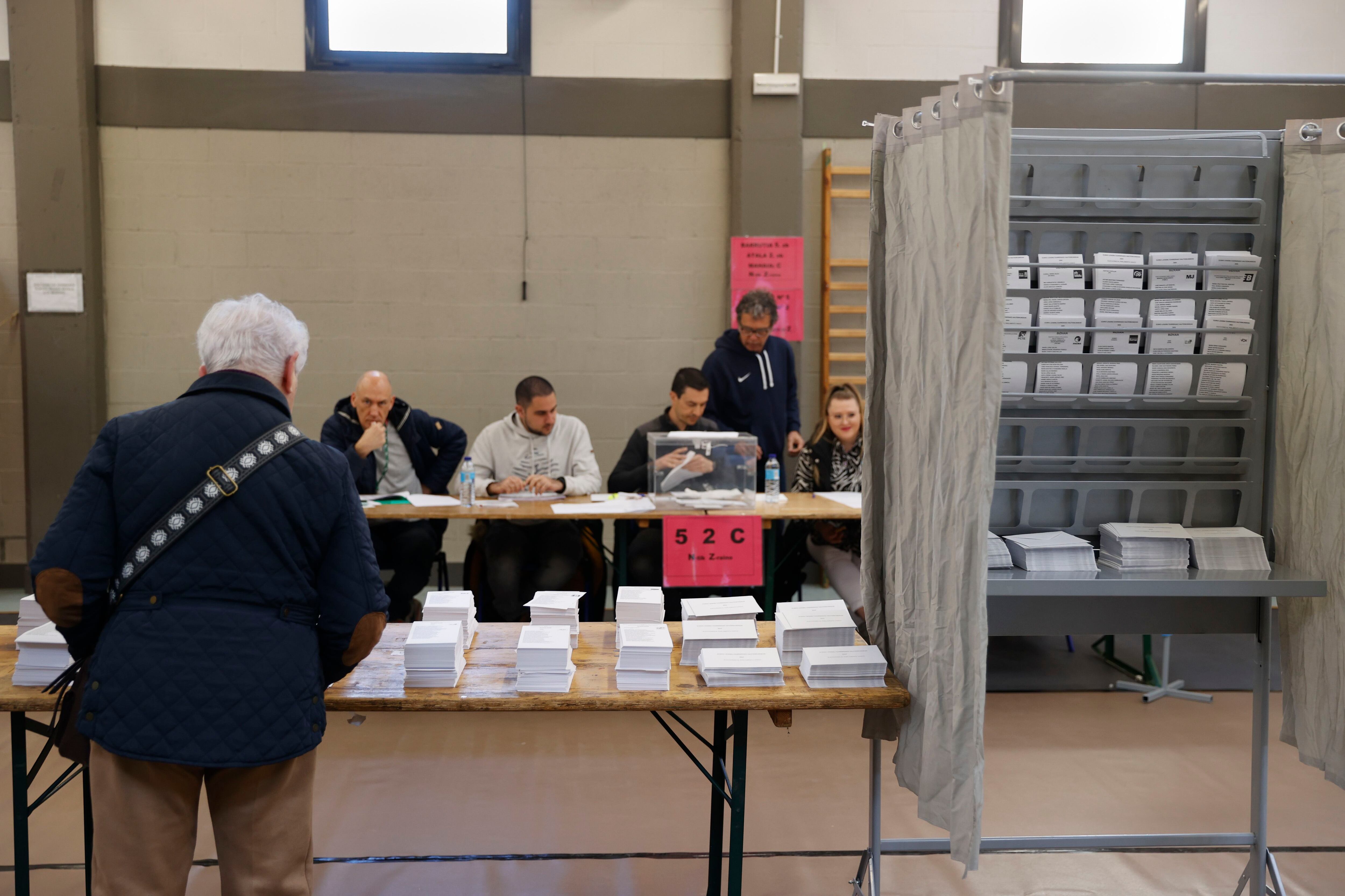 Un hombre escoge papeleta este domingo en un colegio electoral en Durango, Bizkaia.