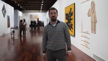 Miki Leal, este jueves en Sevilla en la muestra 'El abrazo'. A la derecha, las obras de Palazuelo (lienzo) y de Pereñiguez.