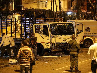 Personal de seguridad inspecciona un camión de la Policía Nacional destruido por un artefacto explosivo en Cali, Colombia, el 8 de enero de 2022.