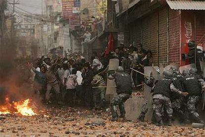 La policía intenta frenar la protesta en favor del restablecimiento de la democracia en una calle de Katmandú.