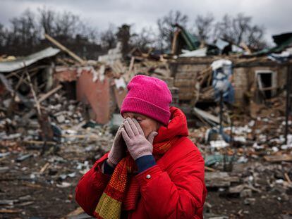 TOPSHOT - Irina Moprezova, 54, reacts in front of a house that was damaged in an aerial bombing in the city of Irpin, northwest of Kyiv on March 13, 2022. - Russian forces advance ever closer to the capital from the north, west and northeast. Russian strikes also destroy an airport in the town of Vasylkiv, south of Kyiv. A US journalist was shot dead and another wounded in Irpin, a frontline northwest suburb of Kyiv, medics and witnesses told AFP. (Photo by Dimitar DILKOFF / AFP)