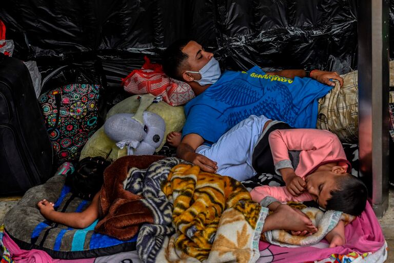 Migrantes venezolanos que esperan regresar a su país afuera de una terminal de buses en Medellín, Colombia.