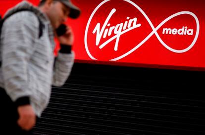 Un transeúnte  pasea frente a una tienda de Virgin Media cerrada por la covid-19 en Londres.