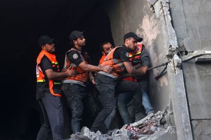 Personal de rescate trabaja entre los escombros de un edificio dañado por los bombardeos en el campo de refugiados de Rafah, este miércoles. 
