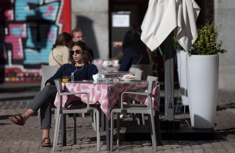 Una mujer, al sol, en una terraza del centro de Madrid.