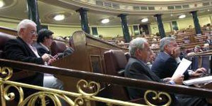 El portavoz parlamentario de IU, Cayo Lara (i), y el diputado del PSOE Alfonso Guerra (d), sentados siguen desde sus escaños el pleno del Congreso de los Diputados. EFE/Archivo