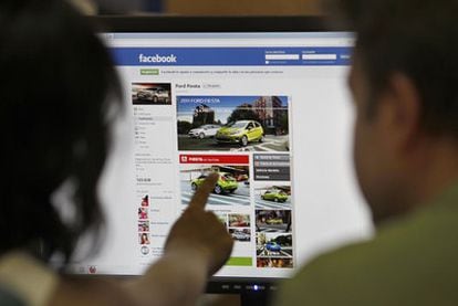 Una pareja busca información sobre automóviles en Facebook.