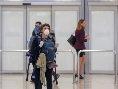 Una mujer protegida con mascarilla llega al aeropuerto de Madrid Barajas este 24 de marzo.