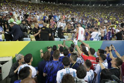 Jugadores de Argentina intentan controlar los disturbios entre hinchas de Brasil y de Argentina.
