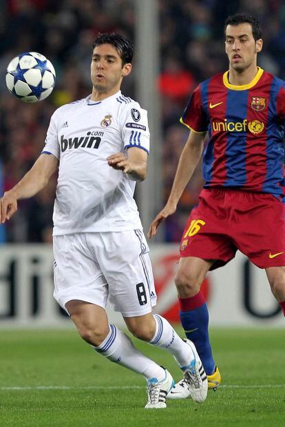 Kaká, una de las sorpresas en la alineación del Madrid, controla la pelota bajo la atenta mirada de Busquets.