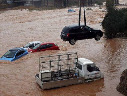 Coches arrastrados por el agua en Sagunto. El cambio climático aumenta los fenómenos extremos, según los expertos.