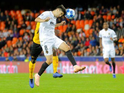 Carlos Soler despeja de cabeza el balón.