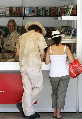 Dos ciudadanos, en una de las casetas de la Feria del Libro.