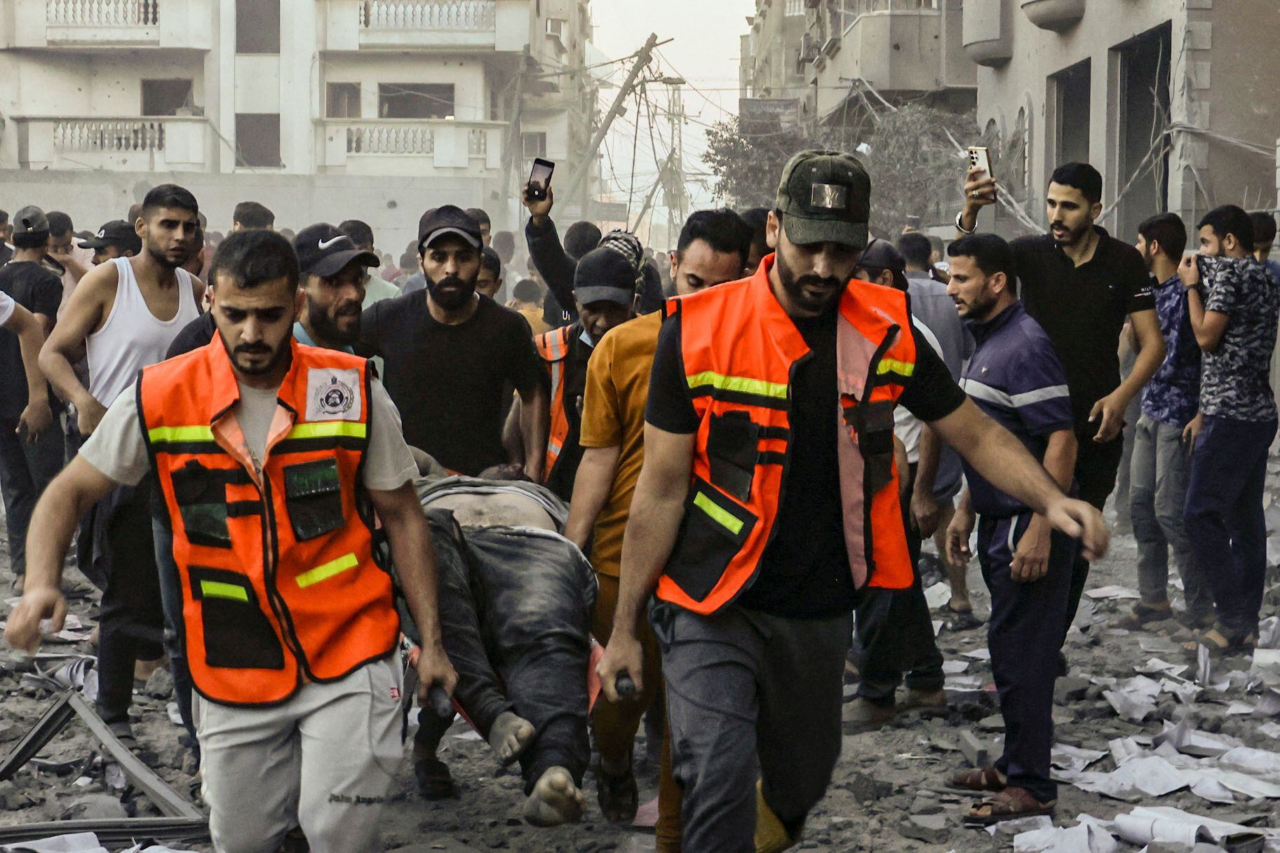 Rescuers remove the body of a man killed in an Israeli strike on Rafah in the southern Gaza Strip on October 15, 2023. Israel embarked on a withering air campaign against Hamas militants in Gaza after they carried out a brutal attack on Israel on October 7 that left more than 1,400 people killed in Israel. (Photo by MOHAMMED ABED / AFP)