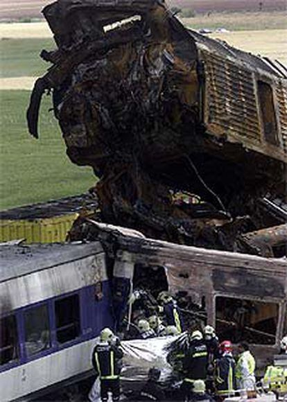 La máquina del tren de mercancías aparece destrozada sobre los vagones del Talgo.