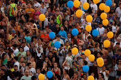 Decenas de personas miran unos globos lanzados al aire durante la marcha del Orgullo Gay.