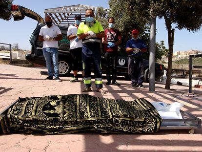 Familiares y trabajadores del cementerio de Melilla rezan ante el cadáver de Kozal Ahmad.