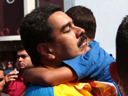 Maduro abraza a un ni&ntilde;o en un barrio de Caracas.