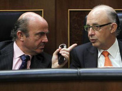 El ministro de Econom&iacute;a, Luis de Guindos, conversa con el ministro de Hacienda, Crist&oacute;bal Montoro, en el Congreso.
