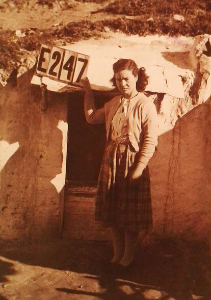 Una vecina a la puerta de su cueva en el Camino de Valderribas (Cerro del Tío Pío, Vallecas). La mujer sostiene el número de expediente para la ficha del Censo de Infraviviendas de Madrid elaborado entre 1957 y 1963.