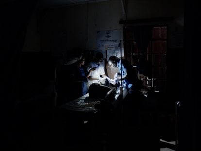 Un equipo de cirujanos intentando operar sin apenas luz en el Hospital Público de Kabala, Sierra Leona. La imagen pertenece a una serie documentada por The Kids Are Right.