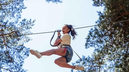 Una adolescente disfruta de una tirolina en un campamento organizado por el Gobierno regional.