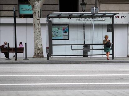 Una mujer espera al autobús en Barcelona.