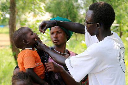 Un sanitario administra la vacuna a un niño de la aldea de Kiech Kuon.
