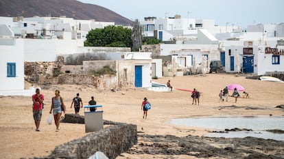 Varias personas pasean y disfrutan de la playa en Caleta de Sebo en La Graciosa (Canarias). 