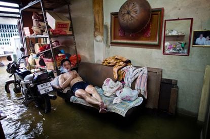 Un hombre ve la tele en su casa inundada, en el barrio de China Town