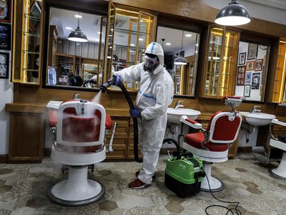 Un trabajador desinfecta una barbería en Roma este viernes.