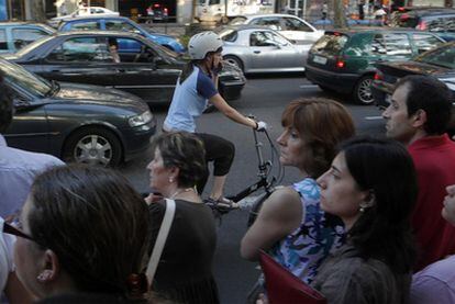 Una ciclista circula en la jornada de huelga ante una parada de autobús.