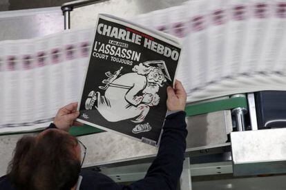 Un empleado de una imprenta sostiene una copia de la última edición del semanario francés 'Charlie Hebdo'.