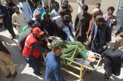 Varios hombres trasladan a una herida tras el terremoto en Harnai, Paquistán.