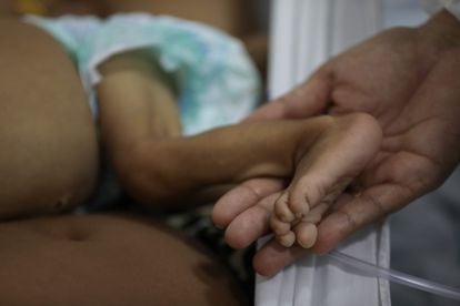 Una persona sostiene el pie de un infante yanomami dentro de las instalaciones del hospital pediátrico de Santo Antonio, en Boa Vista. Este es el único hospital pediátrico del lugar; ahí se encuentran 59 críos indigenas ingresados, incluidos ocho yanomami en estado crítico.