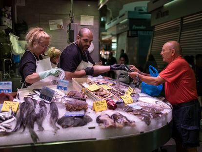 Un hombre paga la compra con tarjeta en una parada del mercado de Sants de Barcelona, este viernes.